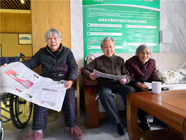 麓山片区高端养老院一暄康养南门分院内，赖奶奶和几位新朋友一起看报纸