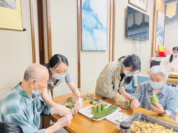 志愿者和爷爷奶奶一起做竹筒饭